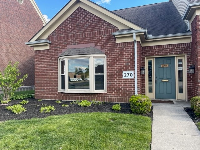 Brick office suite at 270 James Bohanan Drive with a teal front door and bay window